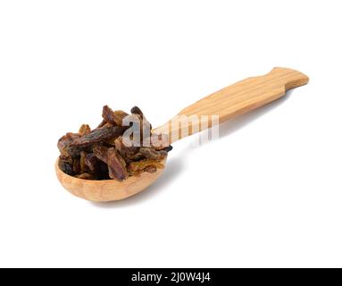 Bouquet de raisins secs bruns séchés dans une cuillère en bois isolée sur fond blanc Banque D'Images