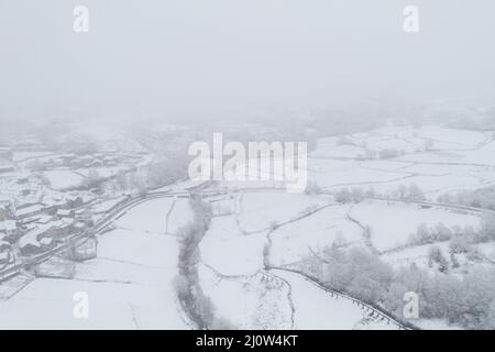 Vue aérienne par drone d'une route et d'un village isolé couvert de neige dans le nord du Portugal, Vila Real Banque D'Images