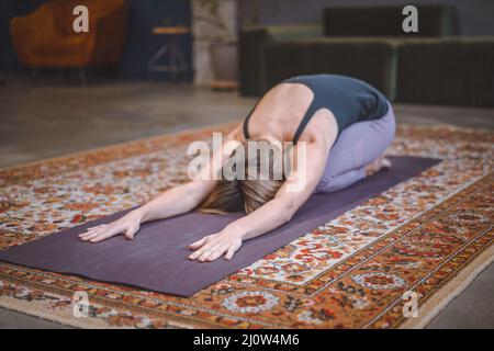 La femme pratique les asanas de yoga le matin pour l'énergie pour toute la journée. Concept de santé, longévité, silhouette mince. Gros plan Banque D'Images