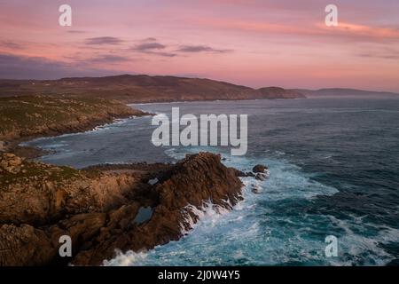 Vue sur les drones du Cap Tourinan au coucher du soleil avec des nuages roses, en Espagne Banque D'Images