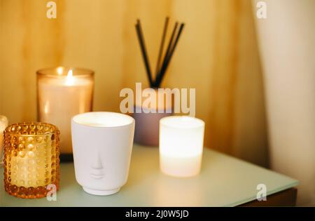 Beaucoup d'éclairage brûlant bougies parfumées et bâtons d'encens aromatiques sur la table, lieu de méditation à la maison Banque D'Images