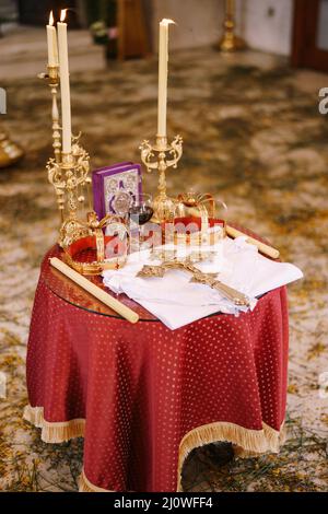 Table avec des couronnes, des bougies, un crucifix et une bible dans l'église de Saint-Sava à Tivat Banque D'Images