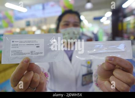 HANGZHOU, CHINE - 21 MARS 2022 - un employé d'une pharmacie présente des réactifs de test d'antigène COVID-19 à Hangzhou, dans la province de Zhejiang en Chine orientale, Banque D'Images