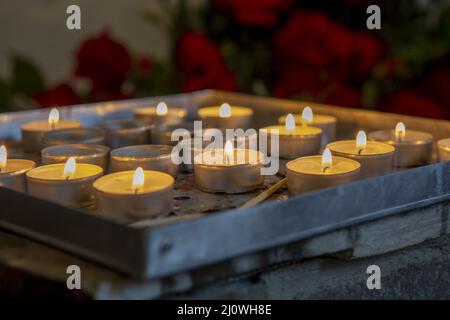 Bougies de prière brûlantes à l'intérieur d'une église catholique.Lumières à thé allumées.Mise au point sélective. Banque D'Images