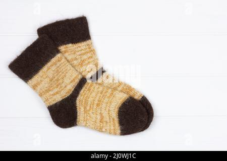 Chaussettes chaudes en fourrure de chien tricoté blanc pour hommes sur fond de bois blanc avec espace pour copier, vue du dessus Banque D'Images
