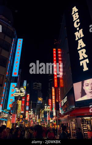 La vie nocturne animée dans la rue du quartier commerçant de Shibuya. T Banque D'Images