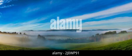 Exploration des collines rurales de Berwick (sud-ouest de Dunedin) au lever du soleil par une journée glaciale avec peu de brouillard et de brouillard qui traverse les vallées Banque D'Images