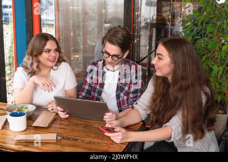 Les étudiants de la première année qui parlent ensemble étudient dans un café en partageant leurs histoires ou leurs attentes avec des lumières qui s'allument sur l'île Banque D'Images