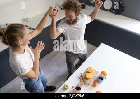 Valser dans une nouvelle maison jeune couple dansant célébrant leur nouvel achat d'acheter leur propre maison. Bonne nouvelle famille à la cuisine Banque D'Images