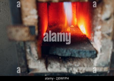 Forgeron four avec flamme chaude. Smith chauffage de fer morceau d'acier dans le feu de forge rouge-chaud Banque D'Images