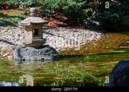 Lanterne traditionnelle en pierre toro au bord de l'étang, dans le jardin du château de Nagoya. Japon Banque D'Images