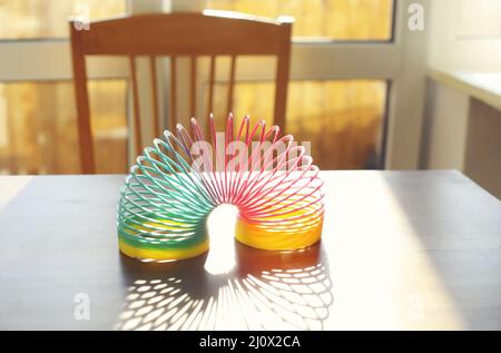 Ressort arc-en-ciel magique anti-stress sur la table dans la salle ensoleillée Banque D'Images