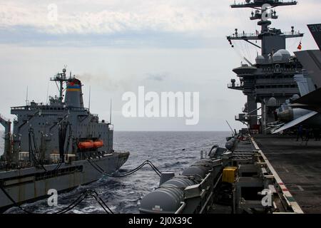 MER DES PHILIPPINES (19 mars 2022) le lubrificateur USNS Guadalupe (T-AO 200) de la flotte de ravitaillement militaire effectue un réapprovisionnement en mer avec le porte-avions USS Abraham Lincoln (CVN 72) de la classe Nimitz. Abraham Lincoln Strike Group est en cours de déploiement prévu dans la zone d'exploitation de la flotte américaine 7th afin d'améliorer l'interopérabilité par le biais d'alliances et de partenariats tout en servant de force d'intervention prête à l'emploi pour soutenir une région Indo-Pacifique libre et ouverte. (É.-U. Photo de la marine par la spécialiste en communication de masse apprenti Julia Brockman) Banque D'Images