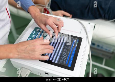 Équipement médical pour électrocardiogramme. Médecins effectuant un test ECG sur un patient masculin. Diagnostic de maladie cardiaque crise cardiaque, tachycarne Banque D'Images