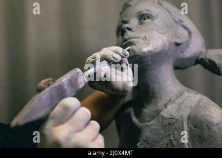 Le sculpteur d'homme crée une sculpture de femme humaine en buste sculptés. Atelier de création d'artisanat de statue Banque D'Images