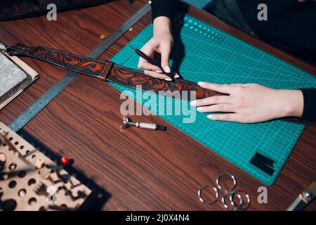 Tanner femme faisant des articles en cuir sur l'atelier. Processus de travail de l'artisan du cuir Banque D'Images