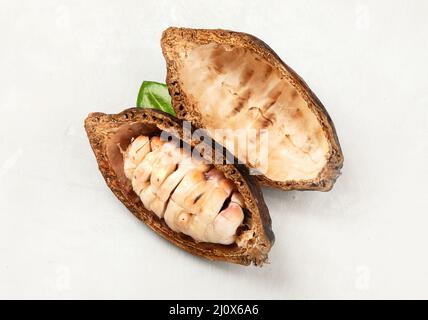 Gousse de cacao frais coupée exposant les graines de cacao sur fond blanc, vue du dessus. Banque D'Images