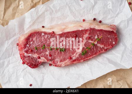 Gros morceau entier de viande de boeuf brute, stripline sur papier parchemin blanc Banque D'Images