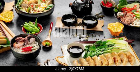 Cuisine asiatique avec divers ingrédients sur fond sombre. Panorama. Banque D'Images