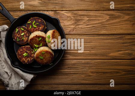 Côtelettes faites maison de poisson, de poulet ou de viande sur poêle à frire en fonte noire Banque D'Images