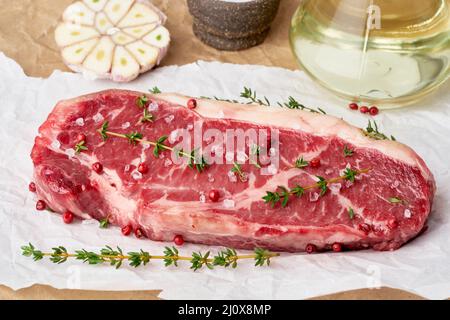 Gros morceau entier de viande de boeuf brute, stripline sur papier parchemin blanc Banque D'Images