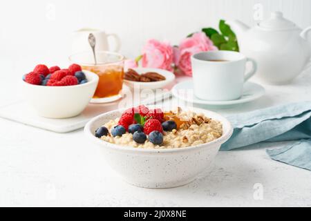 Porridge de flocons d'avoine avec bleuets, framboises, confiture et noix, vue de dessus. Petit déjeuner avec baies Banque D'Images