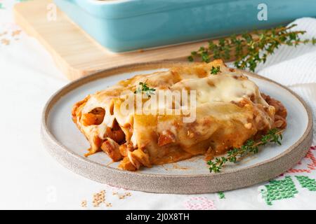 Pâtes de cannelloni avec remplissage de bœuf haché, tomates, cuites au bechamel Banque D'Images