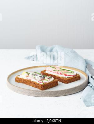 Smorrebrod salé, deux sandwichs traditionnels danois. Pain de seigle noir avec anchois Banque D'Images