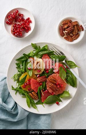 Vue de dessus de la salade de fruits aux agrumes avec des noix, des feuilles de laitue verte. Nourriture équilibrée. Épinards à l'orange Banque D'Images