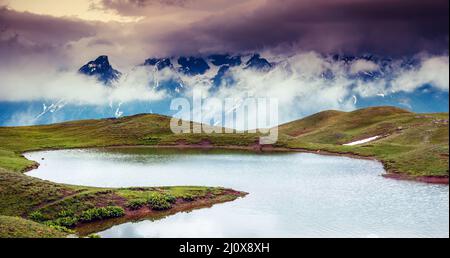 Paysage fantastique avec le lac Koruldi et ciel couvert au pied de Mt. Ushba. Haut Svaneti, Mestia, la Géorgie, l'Europe. Montagnes du Caucase. Beauté w Banque D'Images