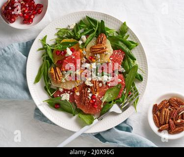 Fruits salade d'agrumes avec noix. Épinards à l'orange, au pamplemousse, aux pommes, aux pacanes et à la gorgonzola Banque D'Images