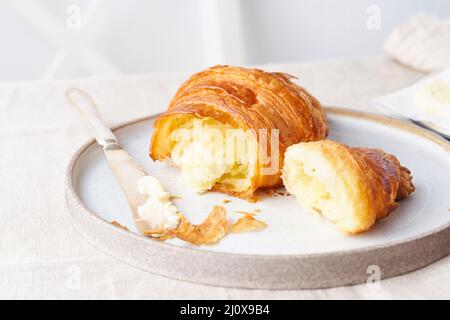 Café avec croissant. Matin ensoleillé et lumineux, petit déjeuner tranquille avec pâtisseries fraîches, vue latérale Banque D'Images