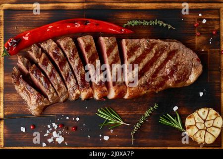 Steak de bœuf moyen à régime cétogène, striploine grillée sur planche à découper. Nourriture Paleo Banque D'Images