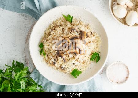 Risotto aux champignons dans l'assiette. Porridge de riz aux champignons et au persil Banque D'Images