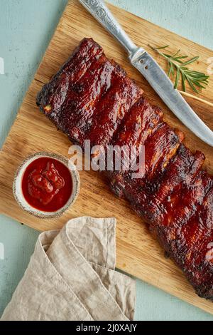 Côtes de porc au barbecue. Recette de cuisson lente. Viande de porc rôtie sur le feu avec sauce rouge Banque D'Images