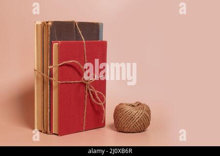 Une pile de vieux livres battus attaché avec la corde de jute, une bobine de corde de jute Banque D'Images