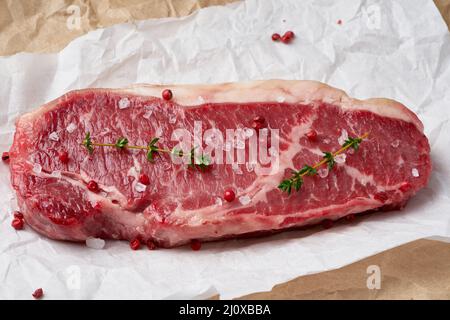 Gros morceau entier de viande de boeuf brute, stripline sur papier parchemin blanc Banque D'Images