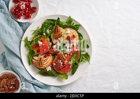 Fruits salade d'agrumes aux noix, feuilles de laitue verte. Vue de dessus. Épinards à l'orange, pamplemousse Banque D'Images