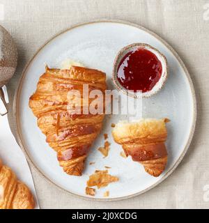 Un délicieux croissants sur la plaque, une boisson chaude en tasse. Petit-déjeuner français le matin avec pâtisseries fraîches Banque D'Images