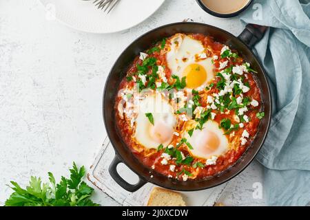Shakshouka, œufs pochés dans une sauce aux tomates, huile d'olive. Cousine méditerranéenne. Banque D'Images