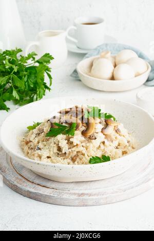 Risotto aux champignons dans l'assiette. Porridge de riz aux champignons et au persil Banque D'Images