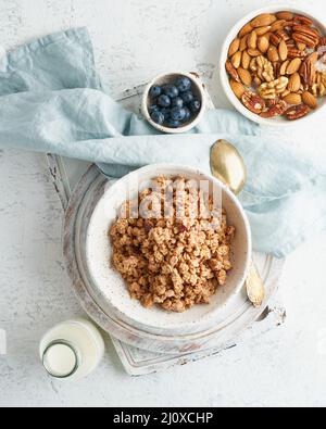 Sécher la granola dans un bol. Petit déjeuner, alimentation saine avec lait en bouteille, flocons d'avoine Banque D'Images