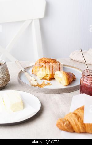 Café avec croissant. Petit déjeuner français traditionnel. Matin ensoleillé, vertical Banque D'Images