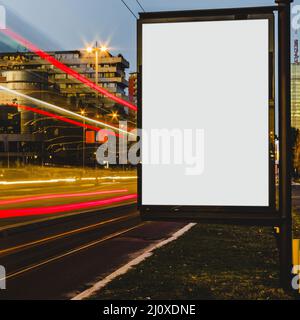 Panneau d'affichage blanc vide avec des sentiers de lumière ville nuit Banque D'Images