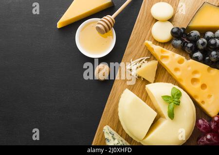 Flat Lay mélanger fromage gastronomique raisins planche à découper avec miel. Concept de photo de haute qualité Banque D'Images