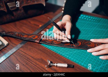 Tanner femme faisant des articles en cuir sur l'atelier. Processus de travail de l'artisan du cuir Banque D'Images