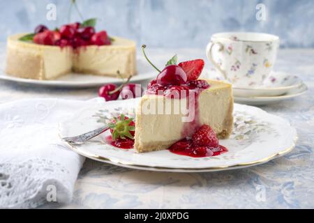 Le cheesecake allemand traditionnel aux fruits de cerise et de fraise sert de gros plan sur une assiette design classique sur une table en bois Banque D'Images