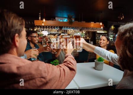 Divers groupes d'amis qui font un toast pendant le dîner Banque D'Images