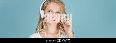 Bannière longue largeur avec portrait d'une jeune femme écoutant de la musique via un casque Banque D'Images