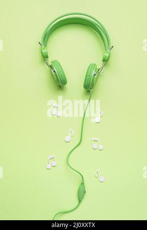 Casque vert avec notes musicales blanches. Photo de haute qualité Banque D'Images